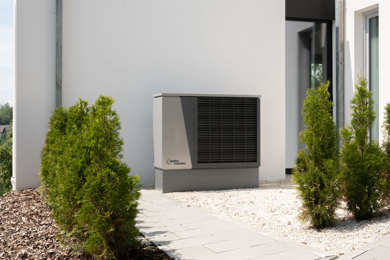 Mastering the First Impression: Your intriguing post title goes here Outdoor air conditioner unit on a modern building surrounded by greenery and landscaping.