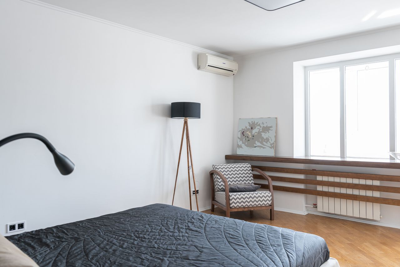 Crafting Captivating Headlines: Your awesome post title goes here Light modern room interior with bed near lamp on floor near armchair and window near painting and air conditioner